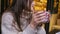 close up woman hands holding cup of cofee in cafe smiling thinking looking around out of window