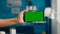 Close up of woman hands holding horizontal mock up green screen chroma key smartphone