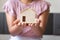 Close-Up of Woman Hands is Holding Housing Model for Money Savings on Her Bedroom, Business Banking or Estate and Financial