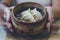 Close up of woman hands holding and showing bowl flameer with chinese ravioli at the restaurant. People and exotic food. Steam and