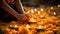 Close up of woman hands lighting candles on flower petals for Diwali festival