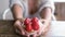Close up of woman hands showing and holding a tasty natural strawberry bakery little cake at the cafe. Concept of snack and