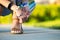 Close up of woman hands tying her open summer sandals shoes on sidewalk in sunny weather