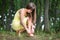 Close up of woman hands tying her open summer sandals shoes in summer park