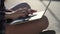 Close-up of woman hands typing text message on laptop outdoors at sunset. Young female student sitting on the library