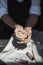 Close up of woman hands works with clay. Female potter kneads and moistens the clay before work.