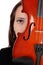 Close up of a woman hiding behind a violin