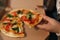 Close up of woman hold slice of vegan pizza in hand. Woman take pizza from pizza box. Vegetarian pizza with fresh