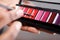 Close up woman holding lip gloss color palette and makeup brush