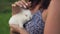 Close Up Woman Holding A Little Cub Rabbit In Her Arms And Stroking Him On Head