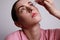 Close-up of woman with injured eye inserting eye-drop. Health care and eyesight concept. Conjuctivitis. Space for space.