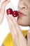 Close-up of a woman kissing a couple of cherries