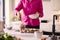 Close Up Of Woman In Kitchen Wearing Fitness Clothing Blending Fresh Ingredients For Healthy Drink