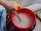 Close-up of a woman kneading glue in a bucket for wallpapering. Renovation of the room and the concept of wallpapering.