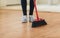 Close up of woman legs with broom sweeping floor