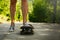 Close up of woman legs in sneakers standing on old skateboard. One leg is standing on board, the other is pushing. Female power