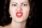 Close-up woman looks straight into the camera on a black background. expresses different emotions, showing teeth