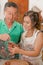 Close up of woman and man ceramist working together on sculpture on wooden table in workshop