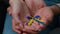 Close-up woman and man hands of multiracial family couple husband wife holding yellow blue colors ribbon national symbol