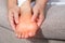 Close-up of a woman massage painful toes at home. Bare foot of woman with painful red bunion Hallux valgus and injury foot,