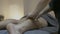 Close up of a woman masseuse gently massaging the calves muscles of her husband in a spa and wellness center -