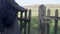 Close-up, The Woman opens an old wooden gate and goes out into the fall field.