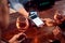 Close Up Of Woman Paying For Drinks At Bar Using Contactless App On Mobile Phone