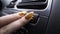 Close-up of woman pressing button on car panel. Action. Woman with manicure presses seat heating button. Button for seat