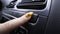 Close-up of woman pressing button on car panel. Action. Woman with manicure presses seat heating button. Button for seat