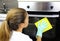 Close up of woman with protective gloves cleaning oven door. Girl polishing kitchen. People, housework, cleaning concept