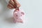 Close up of woman put coin in piggy bank