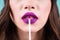 Close up woman puts lipstick, lip gloss on her lips. Bright purple lipstick color. Skin Care Cosmetics