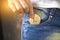 Close-up of woman putting bitcoin in jeans pocket, golden cryptocurrency coin in pocket background photo