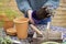 Close Up Of Woman Re-Potting Houseplant Into Larger Compost Filled Pot Outdoors