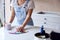 Close Up Of Woman Renovating Kitchen At Home Looking At Paint Swatches On Coffee Break