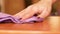 Close-up of a woman`s hand cleaning and wiping the furniture with a microfiber cloth. The woman is doing household chores. Cleanin