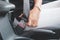 Close-up of a woman`s hand fastening a seat belt in a car