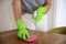 Close-up of woman\'s hand in gloves is wiping the table with cleaning liquid