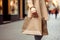 Close up of woman`s hand holding shopping bags while walking on the street