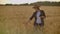 Close-up of woman`s hand running through organic wheat field, steadicam shot. Slow motion. Girl`s hand touching wheat
