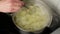 Close up. A woman`s hand is stirring potatoes in a pot of boiling water.