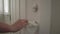 Close up of a woman`s hand using a wet wipe to clean off door knob