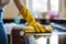 Close up of woman\\\'s hand in yellow rubber gloves cleaning kitchen with rug