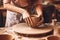 Close-up of a woman\\\'s hands in a ceramic workshop working with clay on a potter\\\'s wheel. Generative AI
