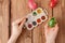 Close-up of woman`s hands painting an easter egg on wooden background