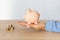 Close-up of a woman\\\'s hands with a piggy bank on the office table. crisis and inflation. Cost Management