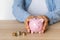 Close-up of a woman\'s hands with a piggy bank on the office table. crisis and inflation. Cost Management