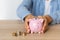 Close-up of a woman\'s hands with a piggy bank on the office table. crisis and inflation. Cost Management