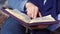 Close-up of woman\'s hands while reading the Bible outside