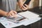 Close up of woman`s hands writing on a paper with hold smartphone on the table and working calculating monthly home expenses, tax